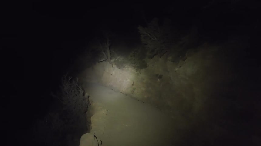 A light shines along a path by a cliff