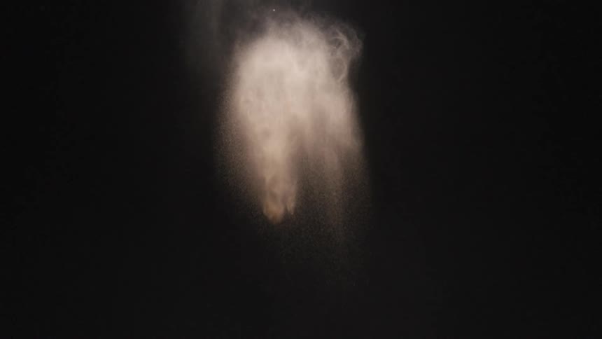 Smoke floats and falls against a black background