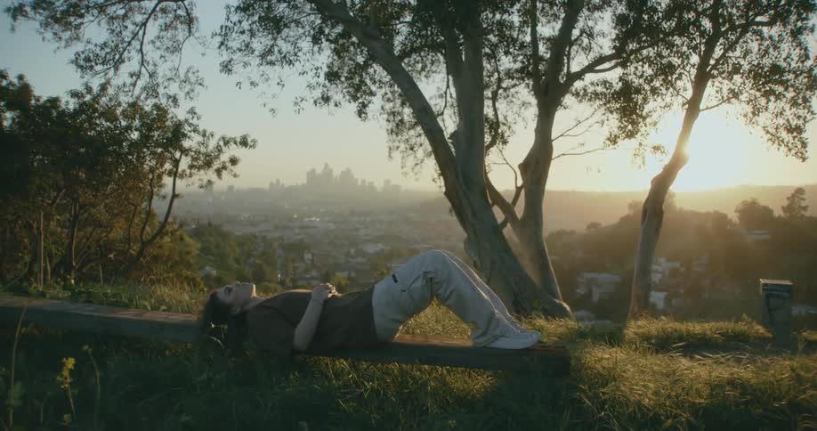 A woman is laying on the hill top