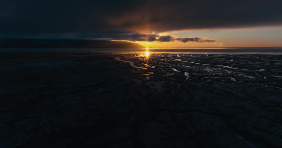 The sun is setting in the horizon of the landscape