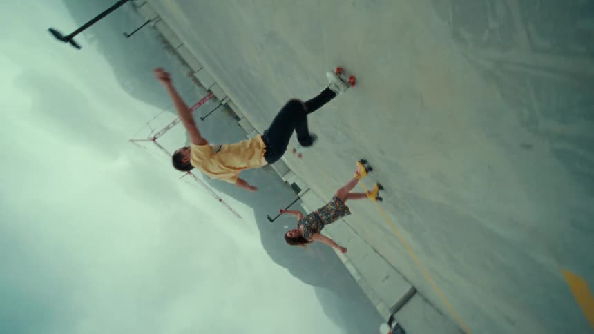 Three people dance in roller skates in a skate park
