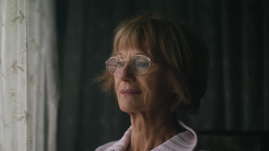 A woman smiles as she looks out the window