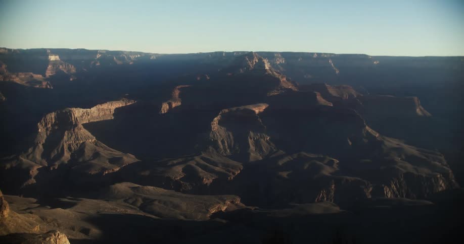 A vast canyon under a clear daytime sky