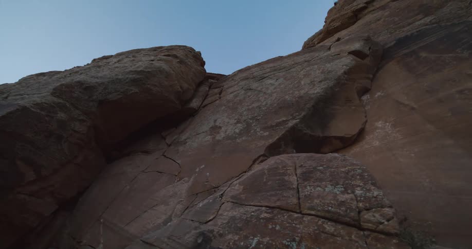 Looking up at a sheer rock cliff