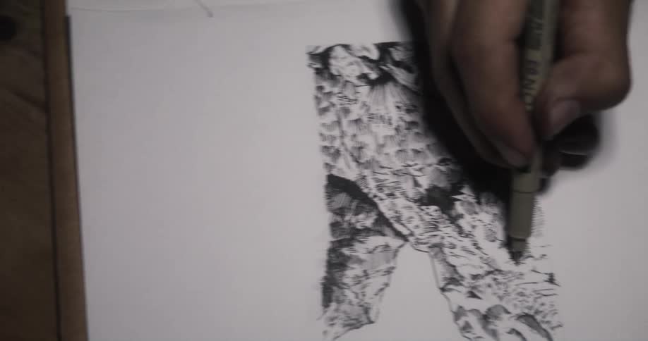 Artist draws with ink using artist pen on sketchpad