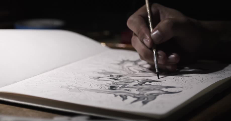 An artist paints a picture in a book