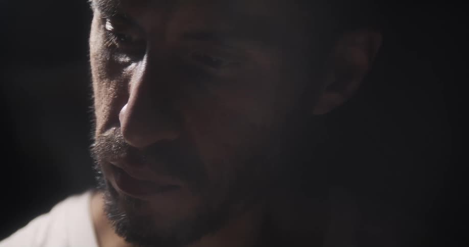 A man is concentrating hard as he looks down