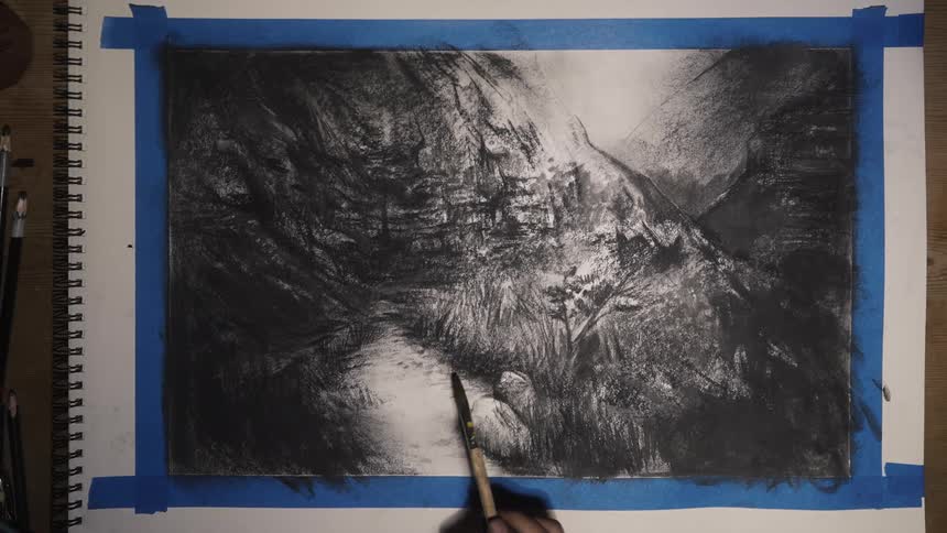 A person sketching a river in a mountain valley