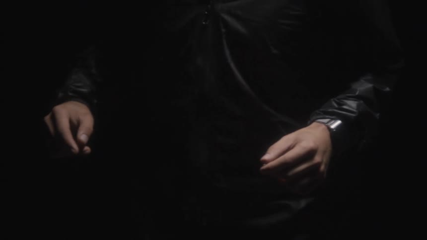 A man wearing all black is running through the night