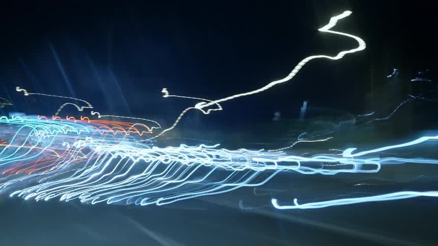 Colorful lines of light flash across the darkness
