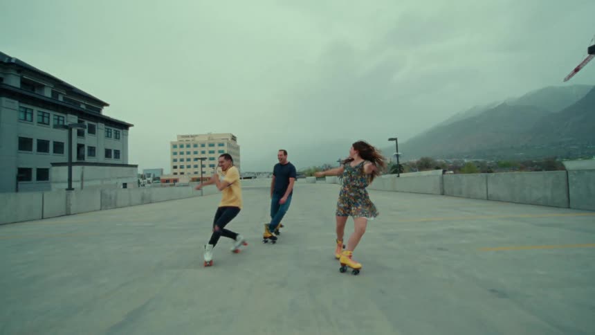 Three people are skating outdoors on concrete
