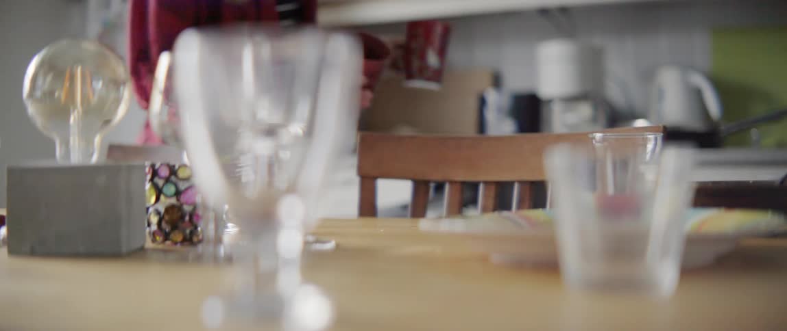 a woman placing glassware and plates into a modern domestic dishwasher.