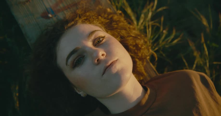 A woman is laying in the grass