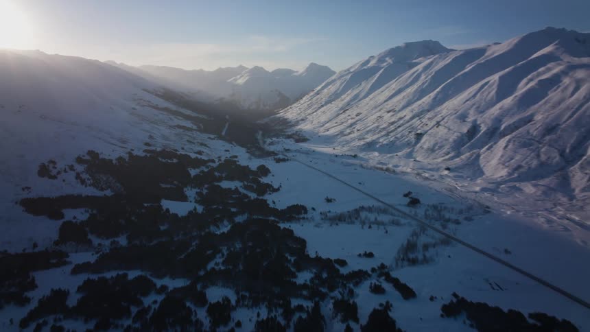 A snowy valley between mountain ridges on a sunny day