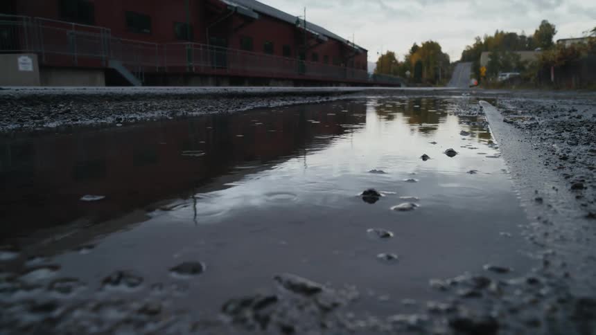 Rain is falling on the puddle
