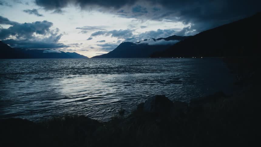 Waves rolling in a lake with mountains in the background