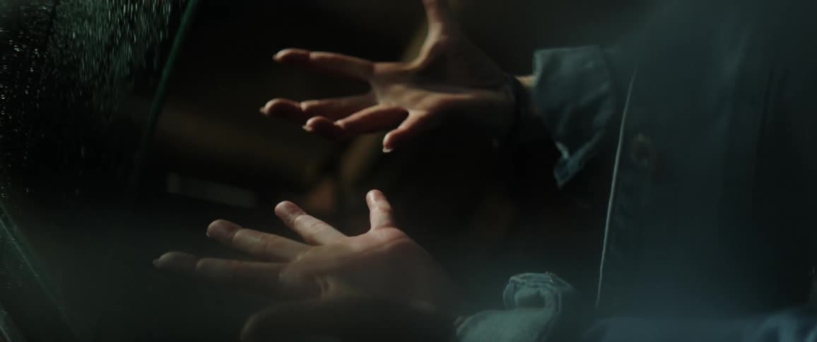 Lights flash on a woman as she moves her open hands around