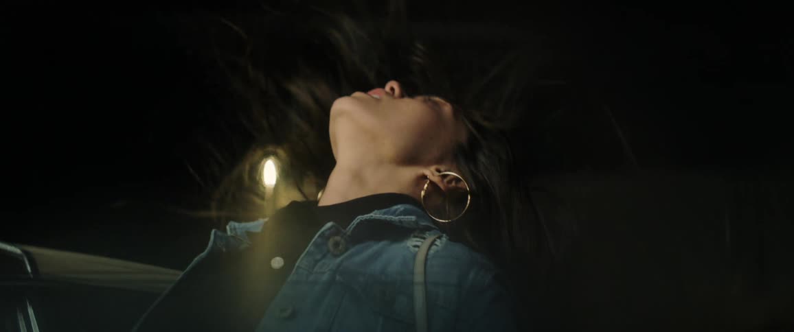 A woman floats in the air next to an open car door
