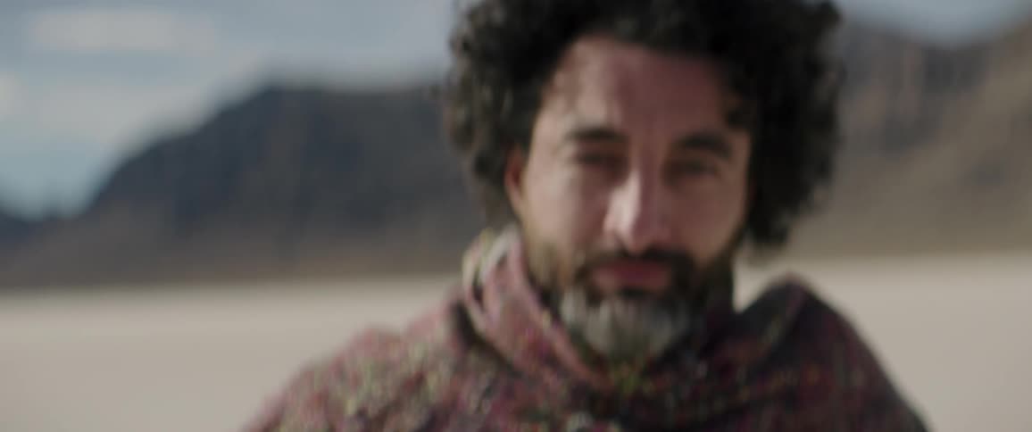 A man is deep in thought as he walks away from mountains