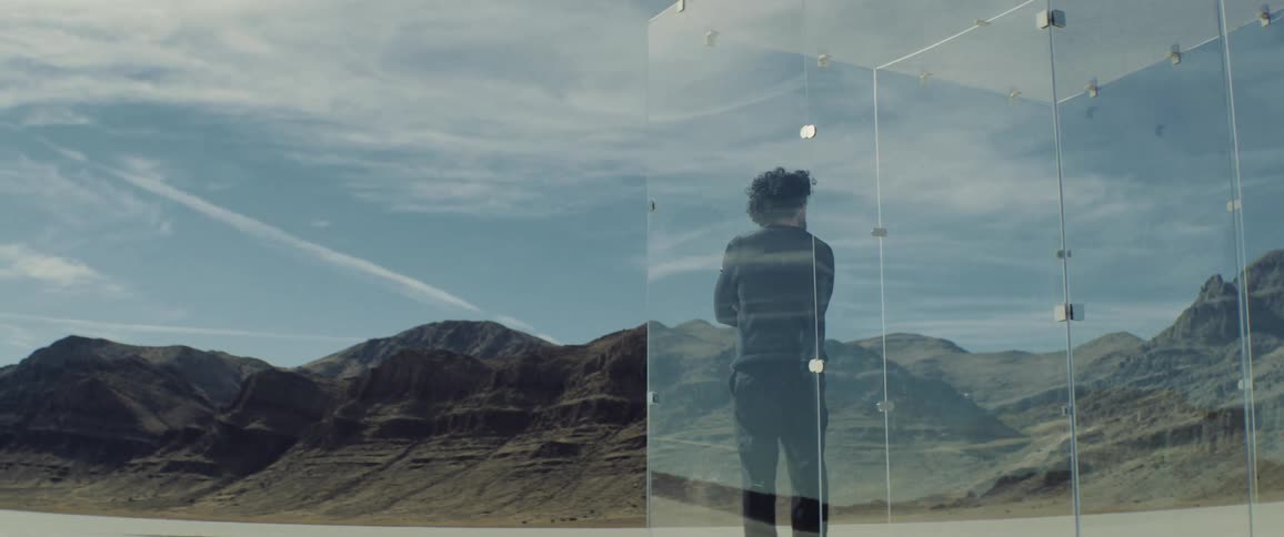 A man stands in a glass cage
