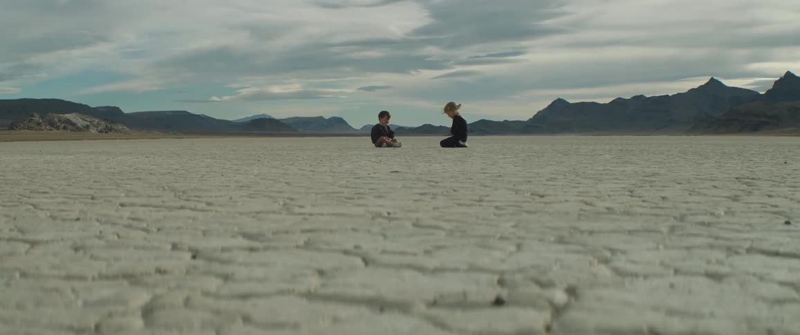 Two children are sitting in the desert