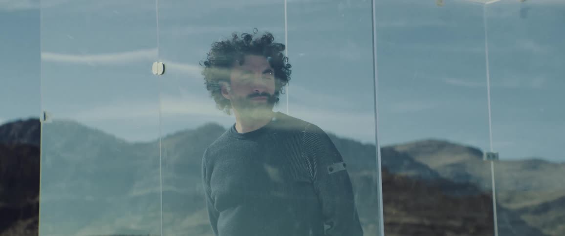 A man is locked in the glass cage in the desert