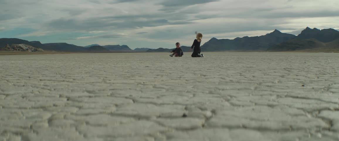 A view of two children playing in the desert