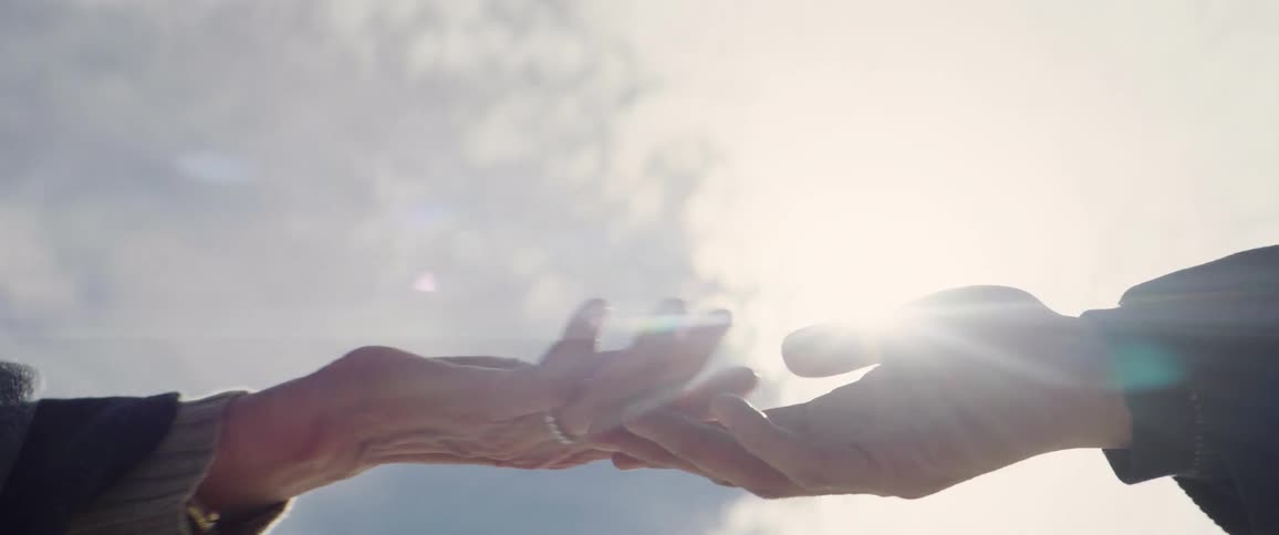 Two people hold hands