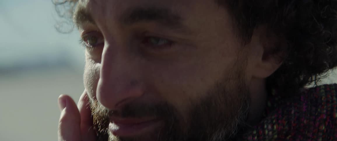 A man is smiling as his face is rubbed