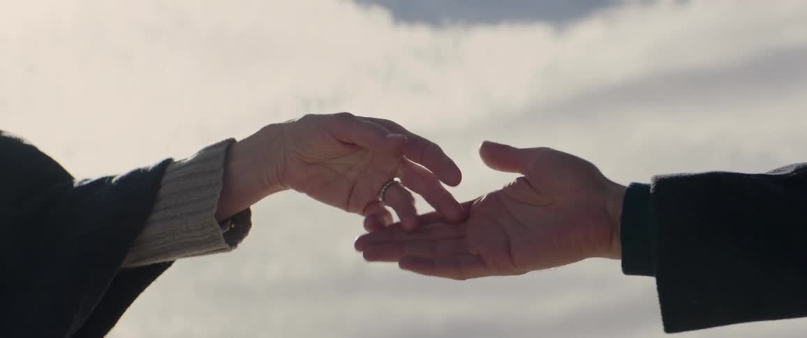 A man and woman touch fingers then reach for each others hands