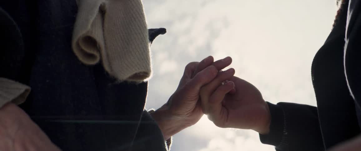 Two people hold hands