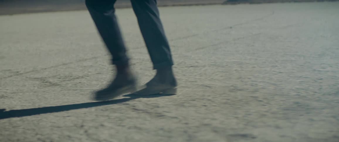 A person is walking through the desert