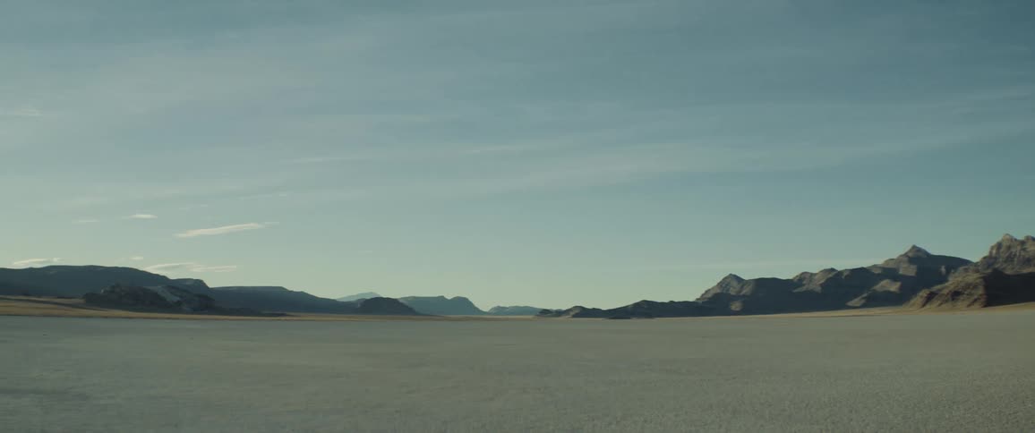 A sandy desert with mountains in the distance