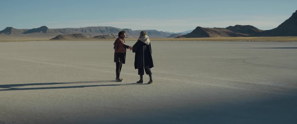 Two people walk toward each other with outreached hands until they touch each other