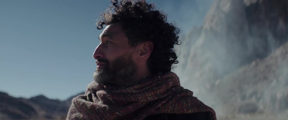 A man is looking around in the desert