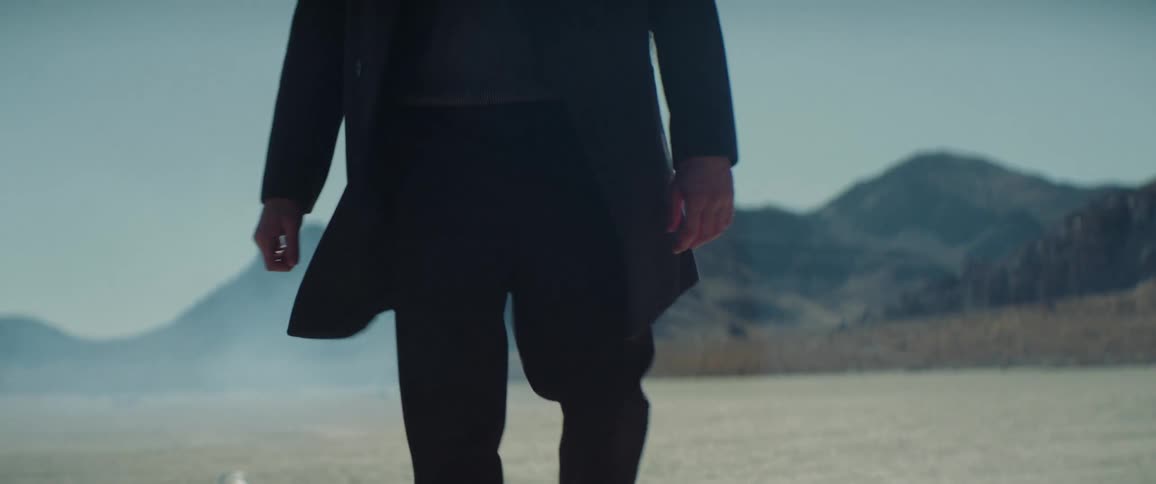 A man walks alone through a barren desert
