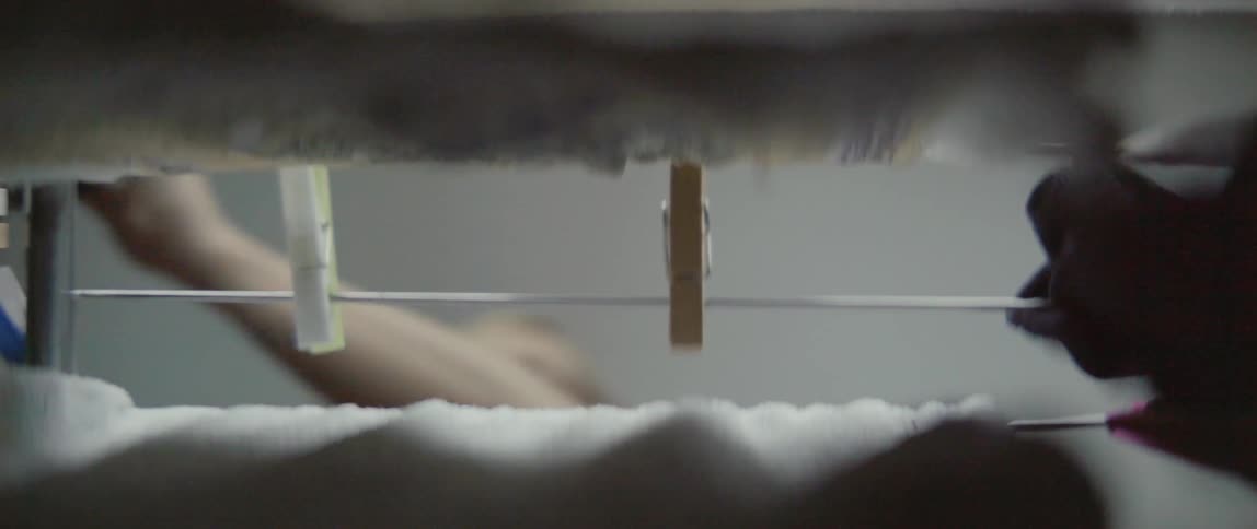 Several pairs of socks hang from a domestic clothesline during a household chore.