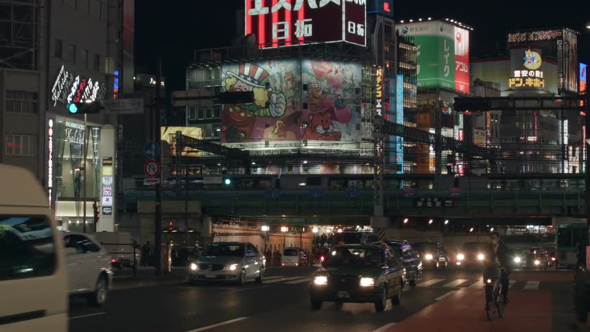 Cars traveling on a busy foreign city street at night
