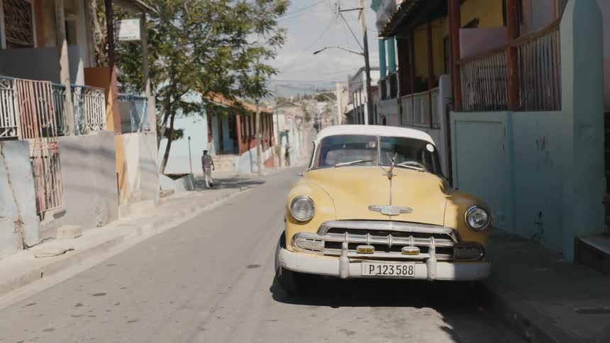 A yellow car is parked in the street