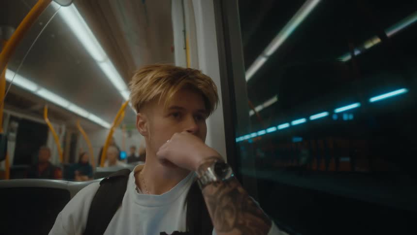 A young man in deep thought while riding on a subway train