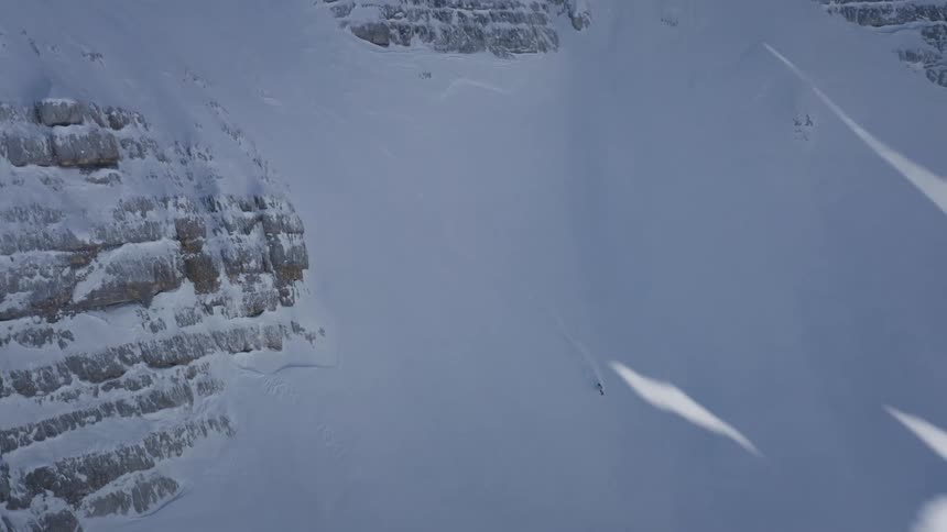 Aerial view of a person skiing down a mountain is displayed