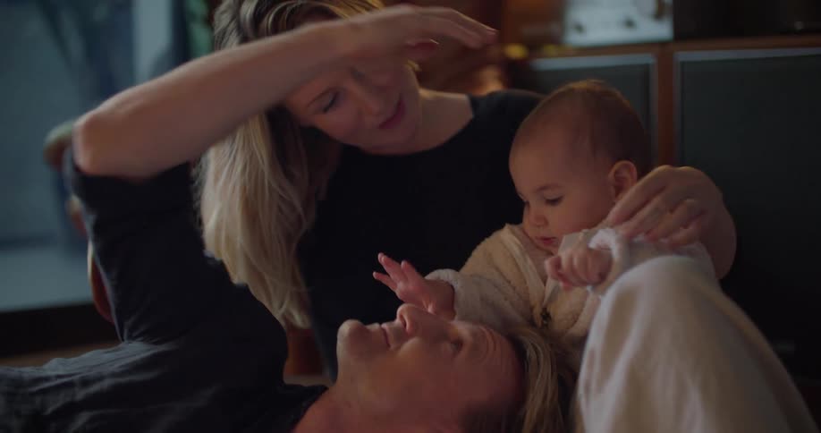 Mother and father play with child at home