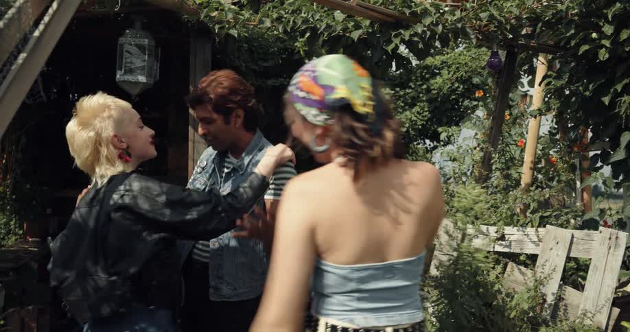 A woman runs and hugs another woman and man and they all jump up and down clearly excited to see one another