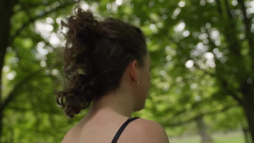 Slow motion footage of a woman walking through a park