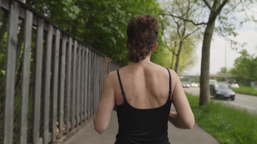Slow motion footage of a woman running down a city street