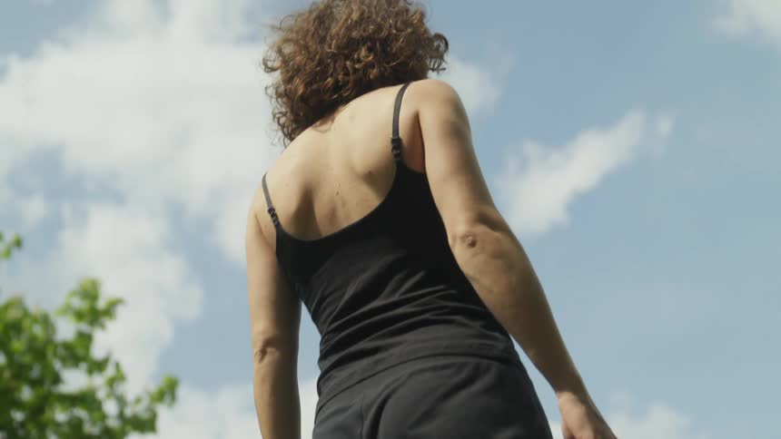 A woman is standing outdoors during the spring time