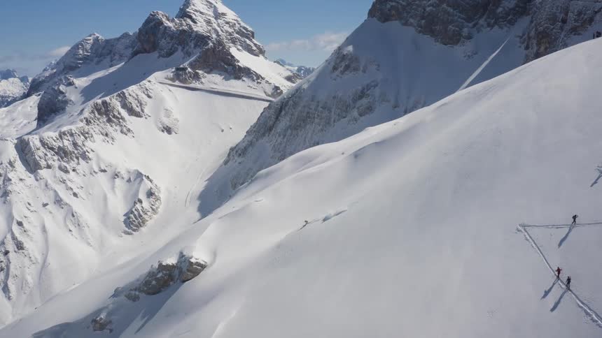 A person is skiing down a mountain during midday