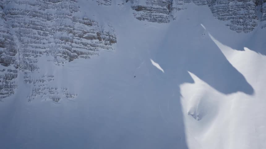 A person is skiing down a mountain in winter