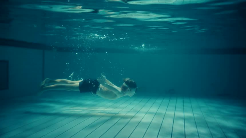 Boy swimming under water in a swimming pool