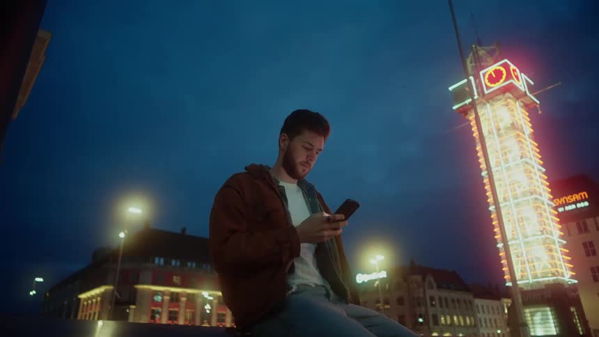 A man is checking his phone outside
